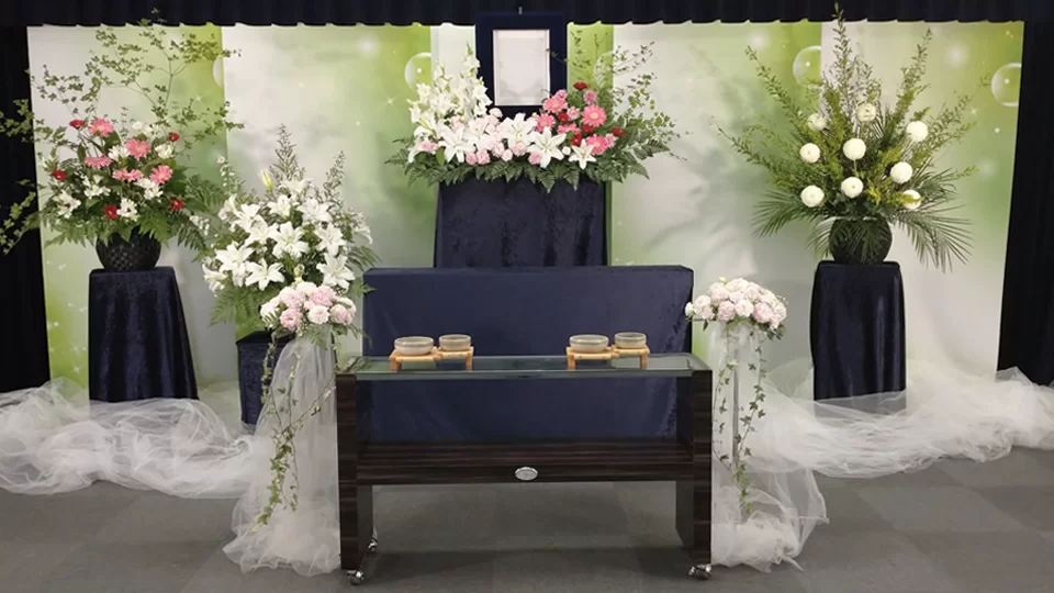 白とピンクの生花が中央に飾られたシンプルで落ち着いた家族葬の祭壇