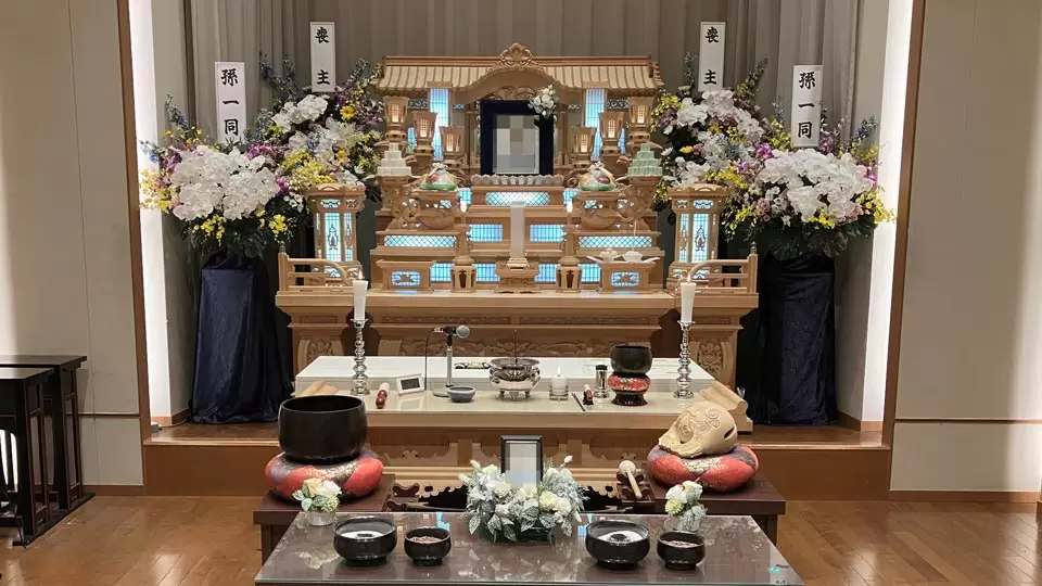 豪華な白木祭壇に灯りがともり、伝統的な設えが印象的な祭壇の写真